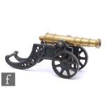 A small replica brass fireside canon on iron carriage with spoke wheels, length 45cm.