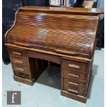 An early 20th Century oak roll top desk, with fitted interior over an arrangement of eight drawers