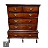 A George III and later oak chest of six drawers with brass drop handles and raised to turned feet,