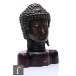 A Chinese bronze shakyamuni buddha head, modelled with downcast eyes and elongated earlobes,