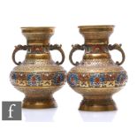 A pair of Chinese cast metal and enamelled vases, each of pedestal form flanked by twin dragon