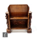 An Arts and Crafts oak combination bookcase and magazine rack, with relief carved fruit pilasters to