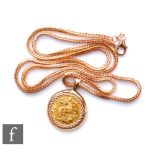 A George V half sovereign loose mounted to a 9ct pendant mount and suspended from a 9ct foxtail link