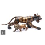 A bronze study of a striped stalking tiger, width 37cm, and a smaller study of a male lion, width