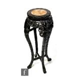 An early 20th Century Chinese carved hardwood jardiniere stand with rouge marble inset top above the