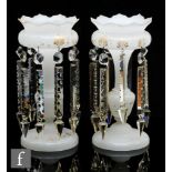 A pair of 19th Century opal glass table lustres, the wide circular foot rising to a slender stem and