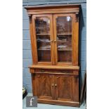 A Victorian walnut cabinet bookcase, with cornice pediment above glazed double doors, acanthus