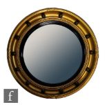 A 20th Century Regency style circular gilt wall mirror with ebonised bezel and ball decoration,