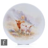 A hand painted porcelain roundel decorated by T. Young with Highland cattle with