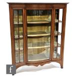 An Edwardian bow front and chequer strung inlaid mahogany display cabinet enclosed by a bevelled