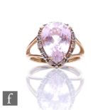A 9ct hallmarked kunzite and diamond cluster ring, pear shaped claw set kunzite within a diamond set