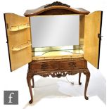 A Queen Anne style walnut cocktail cabinet, the mirrored interior enclosed by a pair of doors