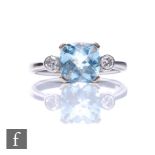 An 18ct hallmarked white gold aquamarine and diamond three stone ring, cushioned square aquamarine