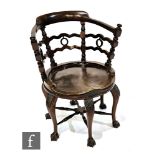 An early 20th Century mahogany swivel desk chair, the wavy lath back interspersed with pierced
