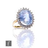 An 18ct hallmarked sapphire and diamond cluster ring, central oval sapphire, length 15mm, within a