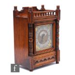 A late 19th Century oak bracket clock carved in the Aesthetic taste, with spindle gallery over
