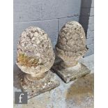 A pair of 20th Century composite stone pineapple finials, on square plinth bases, height 47cm. (2)