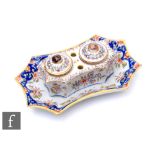 An early 20th Century French Faience twin inkwell decorated in the typical manner with flowers and