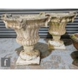 A pair of late 20th Century reconstituted stone garden terrace urns, with moulded mask