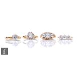 Four 14ct cubic zirconia set rings to include a cluster and a three stones example, total weight