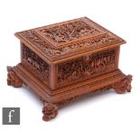 A second quarter 20th Century hardwood table casket, carved in deep relief depicting elephants and