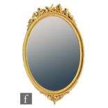 A Victorian oval gilt wall mirror, the reeded and gadrooned frame surmounted with a ribbon and
