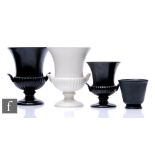 Three Wedgwood campana urns comprising one large in black, one large in white and one smaller in