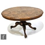 A Victorian figured walnut oval tilt-top breakfast table on turned carved pedestal and