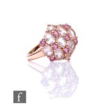 A 9ct hallmarked rose gold morganite and kunzite cluster ring, seventeen claw set stones to an