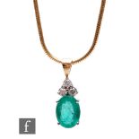 A 14ct emerald and diamond pendant with oval claw set emerald, length 8mm, below three brilliant cut