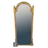 A large Victorian gilt and part ebonised wall mirror, the domed top over turned finials and reeded