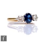 An 18ct hallmarked sapphire and diamond three stone ring, central oval sapphire, length 7mm, flanked