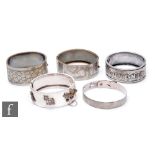Five assorted early 20th Century silver and white metal hinged bangles to include one detailed