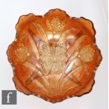 An early 20th Century Carnival glass four footed bowl with deep body and wave edged rim, by Dugan,