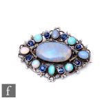 An Arts and Crafts silver oval brooch set with opals and sapphires, weight 16g, length 5cm, in the