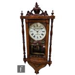 A late 19th Century marquetry veneered walnut wall clock with eight-day movement striking on a bell,