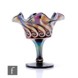An early 20th Century Carnival glass comport with wave edged rim, facet stem and circular spread