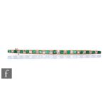 An 18ct emerald and diamond line brooch comprising twenty nine alternating square cut emerald and