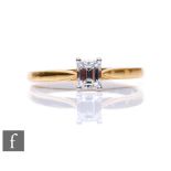 An 18ct hallmarked diamond solitaire, baguette claw set stone, weight approximately 0.40ct, colour