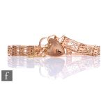 An early 20th Century 9ct rose gold fancy six bar gate bracelet, weight 19g, terminating in