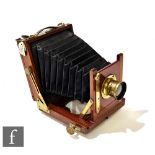 A mahogany and brass half plate camera with black bellows.