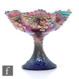 An early 20th Century Carnival glass comport with deep body and wave edged rim raised to a