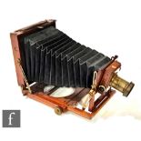 A Thornton Pickard Imperial triple extension half plate mahogany camera, with black bellows.