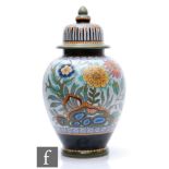 A large Gouda Art Deco Hartog pattern jar and cover decorated with flowers and foliage with