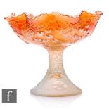 An early 20th Century Carnival glass comport with deep body and wave edged rim on pedestal foot,