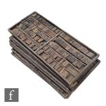 Nine trays of Edwardian or earlier wooden printing blocks, capital letters etc, 37cm x 84cm.