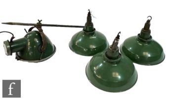 In the manner of Thorlux - A set of four industrial green enamel factory lights, the domed shades