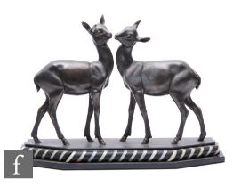 After Irenee Rochard - A spelter study of two young standing deer or fawns, mounted on a black