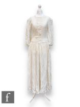 An early 20th Century vintage ivory jacquard wedding dress with a vertical ruched panel to the