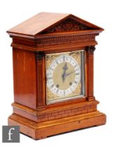 A late 19th Century bracket clock with architectural style oak case, the brass dial with silvered